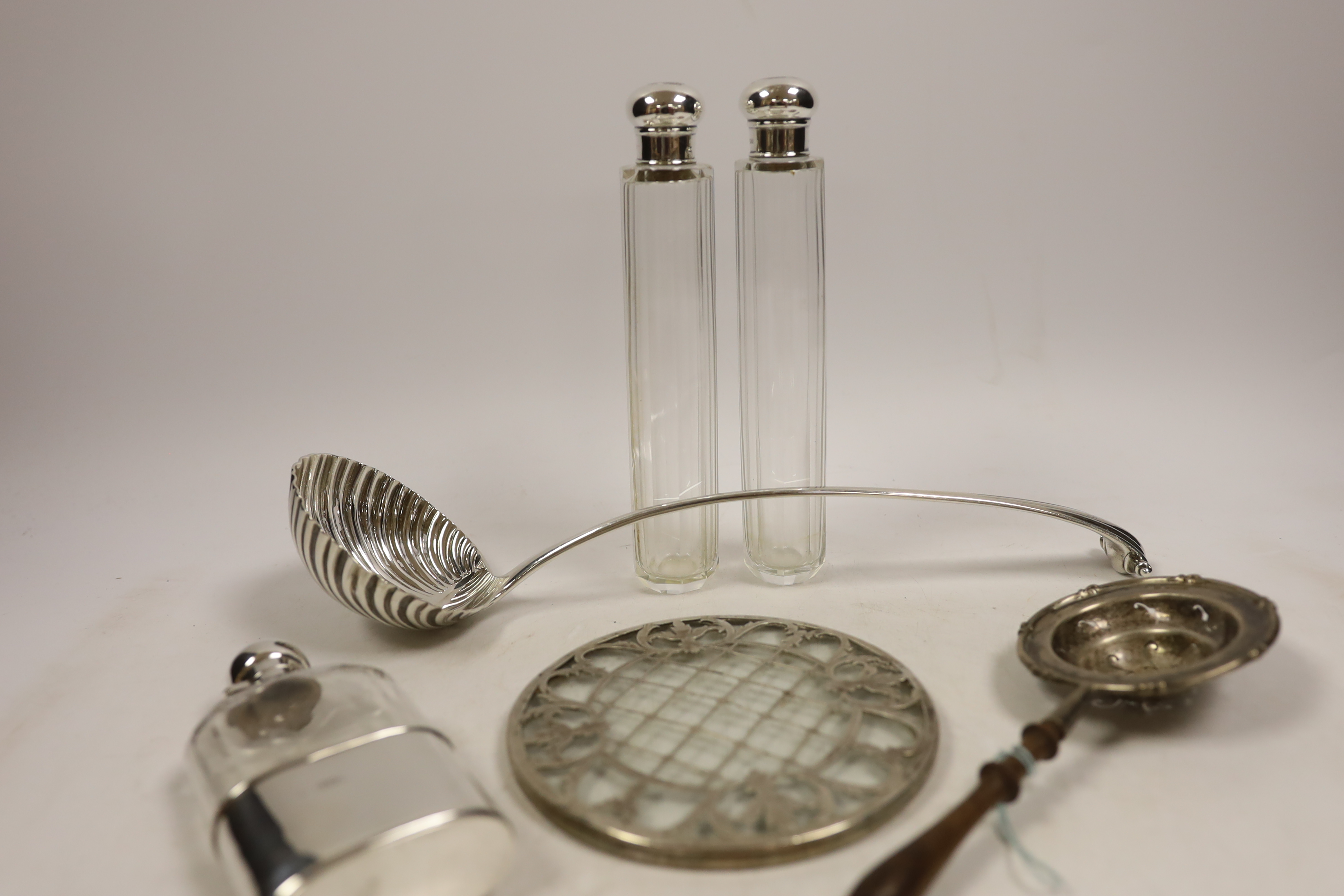 An 18th century silver base mark Onslow pattern soup ladle, indistinct marks and five other items including a silver mounted glass hip flask and a silver tea strainer with wooden handle.